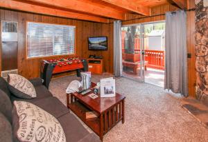 een woonkamer met een bank en een tafel bij Little Brown Bear - Beautiful view, quiet area and an amazing hot tub! in Big Bear Lake