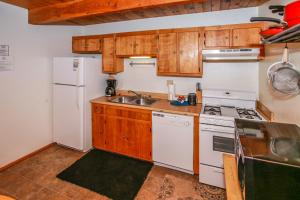 a kitchen with a white refrigerator and a sink at Little Brown Bear - Beautiful view, quiet area and an amazing hot tub! in Big Bear Lake