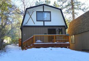 une petite maison avec une terrasse couverte dans la neige dans l'établissement Little Brown Bear - Beautiful view, quiet area and an amazing hot tub!, à Big Bear Lake