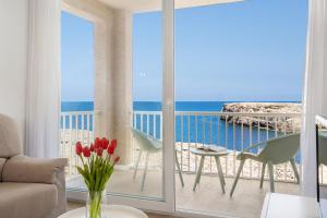 a room with a balcony with a view of the ocean at VORAMAR by 3VILLAS in Cala en Forcat +33 photos