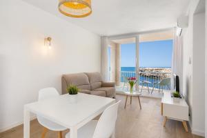 a living room with a white table and a white dining room at VORAMAR in Cala en Forcat