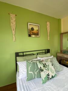 a bedroom with green walls and a bed with pillows at Tanay Panoramic Mountain View Cabin 