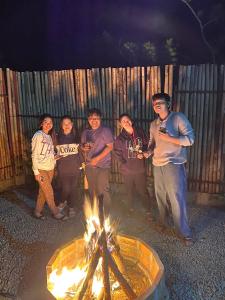 a group of people standing around a fire pit at Tanay Panoramic Mountain View Cabin 