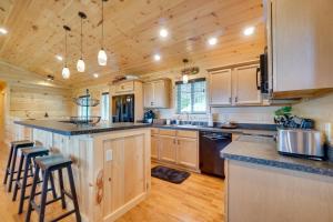 a kitchen with wooden cabinets and a large island with bar stools at Gorgeous Gatlinburg Cabin Large Deck and Hot Tub! in Gatlinburg