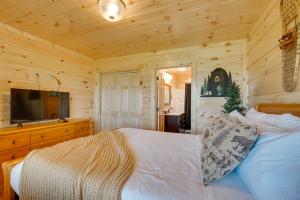 ein Schlafzimmer mit einem Bett und einem TV in einer Hütte in der Unterkunft Gorgeous Gatlinburg Cabin Large Deck and Hot Tub! in Gatlinburg
