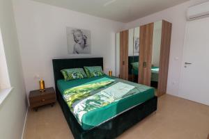 ein Schlafzimmer mit einem großen Bett mit Spiegel in der Unterkunft Apartman SMARAGD Živogošće in Živogošće