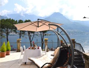 einen Spielplatz mit Sonnenschirm und Schaukel in der Unterkunft Appartamento Belle Epoque vista lago in Onno