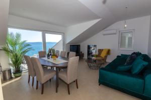 ein Wohnzimmer mit Tisch und Couch in der Unterkunft Apartman SMARAGD Živogošće in Živogošće