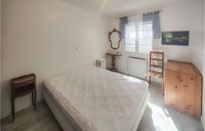 a bedroom with a large white bed and a chair at 2 Bedroom Cozy Home In Portiragnes in Portiragnes