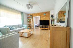 a living room with a couch and a tv at Manni's house with garden & playground in Kuressaare