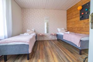 um quarto com duas camas e um espelho em Manni's house with garden & playground em Kuressaare