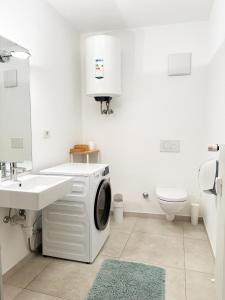 bagno bianco con lavatrice di Lafri Apartment a Bolzano