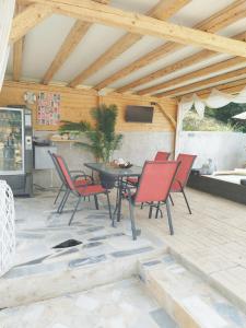 patio con mesa y sillas y cocina en Country House DAFNI, en Vasilikos