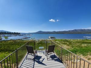 two chairs sitting on a boardwalk next to a lake at Lakefront Cottage - Trip Advisor Certificate of Excellence winner with gorgeous lake views! in Big Bear Lake