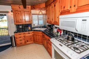 a kitchen with wooden cabinets and a stove top oven at Lakefront Cottage - Trip Advisor Certificate of Excellence winner with gorgeous lake views! in Big Bear Lake