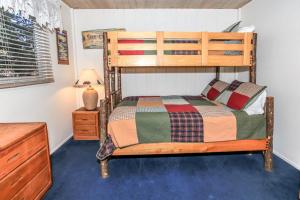 a bedroom with a bunk bed and a night stand at Lakefront Cottage - Trip Advisor Certificate of Excellence winner with gorgeous lake views! in Big Bear Lake