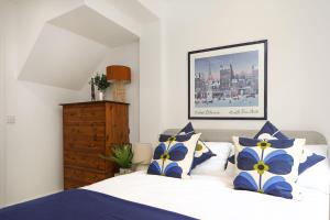 Schlafzimmer mit einem Bett mit blauen und weißen Kissen in der Unterkunft Luxury interior designed 1 bed in London