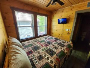 ein Schlafzimmer mit einem Bett in einer Holzhütte in der Unterkunft Dancing Bear Cabin- Relax & Enjoy! in Sevierville