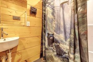 baño con cortina de ducha y pintura de un mono en Dancing Bear Cabin- Relax & Enjoy!, en Sevierville