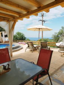 a patio with a table and an umbrella at Country House DAFNI in Vasilikos