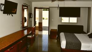 1 dormitorio con 1 cama y vestidor con TV en Hotel Maioris Guadalajara, en Guadalajara