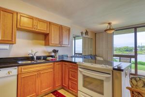 a kitchen with wooden cabinets and a sink at Kuhio Shores 107 in Kukuiula