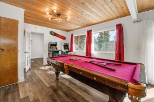 a pool table in a living room with a red cloth sidx sidx sidx at Family Fun Cabin - Mountain home with Game Room, Hot Tub and Lake Views! in Fawnskin