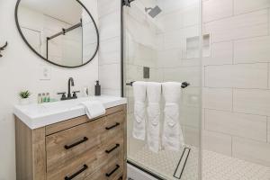 a bathroom with a shower with a sink and a mirror at Family Fun Cabin - Mountain home with Game Room, Hot Tub and Lake Views! in Fawnskin +22 photos