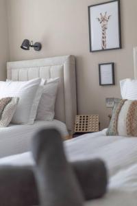 - une chambre avec un lit et une photo de girafe sur le mur dans l'établissement The Rosewood, Cornwall., à Roche