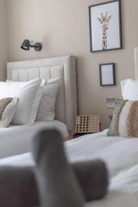 a bedroom with a bed and a giraffe picture on the wall at The Rosewood, Cornwall. in Roche