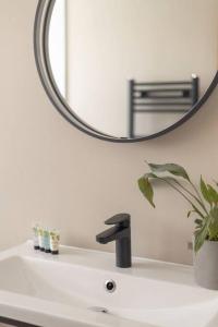La salle de bains est pourvue d'un lavabo, d'un miroir et d'un robinet. dans l'établissement The Rosewood, Cornwall., à Roche