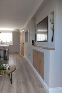 een woonkamer met een tafel en een tv aan de muur bij The Rosewood, Cornwall. in Roche