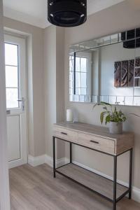 a bathroom with a wooden table and a mirror at The Rosewood, Cornwall. in Roche