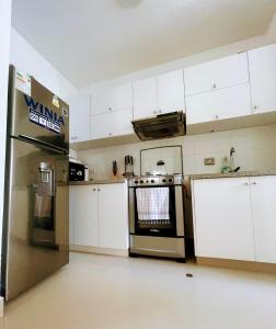 a kitchen with white cabinets and a stainless steel oven at Dpto 3 hab en Piura - GARDEN 360~ in Piura