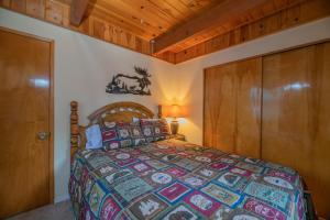 um quarto com uma cama e um tecto de madeira em Far Enough Cabin - Chalet style cabin, walking distance to the trails! Foosball table! em Sugarloaf