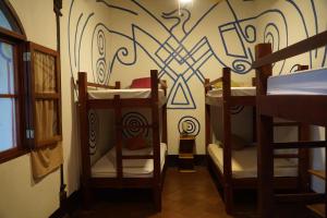 a room with two bunk beds and a wall with graffiti at Cueva Nica in Granada