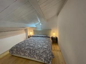 a bedroom with a bed and a wooden floor at Casa Chiocciola Eleonora in SantʼAntìoco