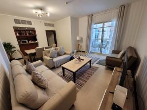ein Wohnzimmer mit einem Sofa und einem Tisch in der Unterkunft Marina Deluxe 2, family only in King Abdullah Economic City