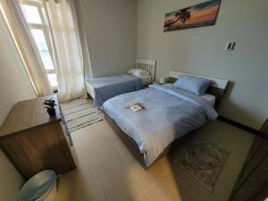 ein kleines Schlafzimmer mit einem Bett und einem Fenster in der Unterkunft Marina Deluxe 2, family only in King Abdullah Economic City