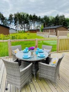 a patio with a table and chairs on a deck at Hollicarrs - Bumblebee Lodge in York