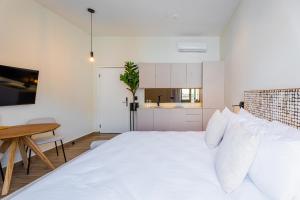 une chambre avec un grand lit blanc et une table dans l'établissement Hotel Boutique Casa Marichu con Piscina, Rooftop y Balcón en Casco Viejo, à Panama City 21 autres photos