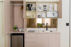 une cuisine avec des armoires blanches et un évier dans l'établissement Hotel Boutique Casa Marichu con Piscina, Rooftop y Balcón en Casco Viejo, à Panama City