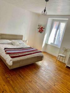 1 dormitorio con 1 cama y suelo de madera en Appartement Dans un village en Auvergne sancy, en Égliseneuve-dʼEntraigues