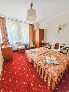 a hotel room with a bed and a red carpet at Villa Jedynak in Świnoujście