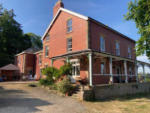an old red brick building with a porch at Penyvoel Hall in Llanymynech