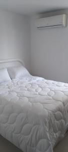 a white bed in a room with a window at Perfecto Apartamento en el Mejor Sector in Cúcuta