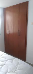 a bedroom with a bed and wooden cabinets at Perfecto Apartamento en el Mejor Sector in Cúcuta