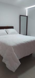 a bedroom with a white bed and a lamp at Perfecto Apartamento en el Mejor Sector in Cúcuta