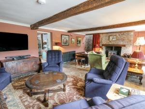 a living room with blue furniture and a fireplace at Ty Sinsir in Crickhowell