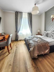 a bedroom with a bed and a desk and a window at Villa Jedynak in Świnoujście